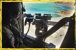 An Aussie RWG loadmaster mans his M134 minigun over Shah Wali Kot Afghanistan.